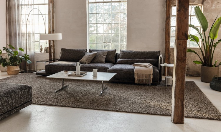 Brauner TEppich kuschelig vor braunem Sofa bleher Wohnzimmer